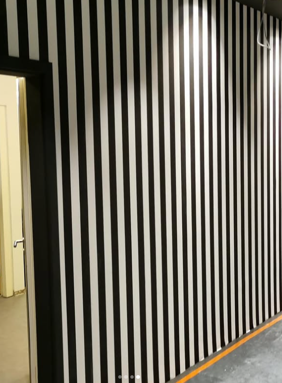 Schwarz-weiss gestreifte Wandtapete in einem Geschaeft des Designer Outlet Salzburg